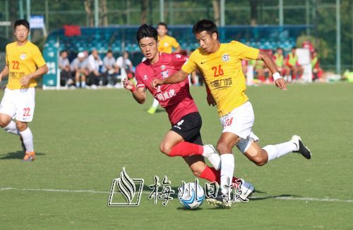 梅县竞技球员马俊亮（右）与宜春江钨威虎球员在拼抢中。（林翔　摄） 
