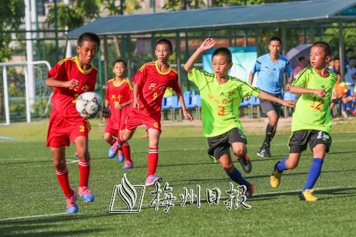 男子足球丙组决赛上五华县代表队与兴宁市代表队双方队员在场上激烈拼抢。（吴腾江　摄）