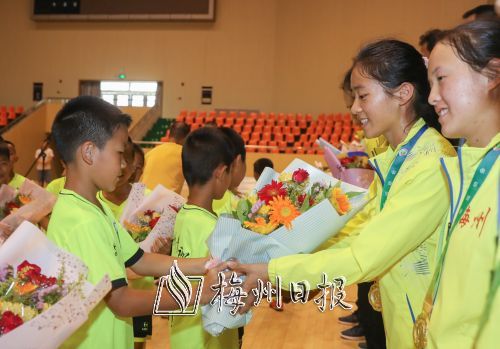 小队员鲜花迎接载誉归来的运动员。（林翔  摄）
